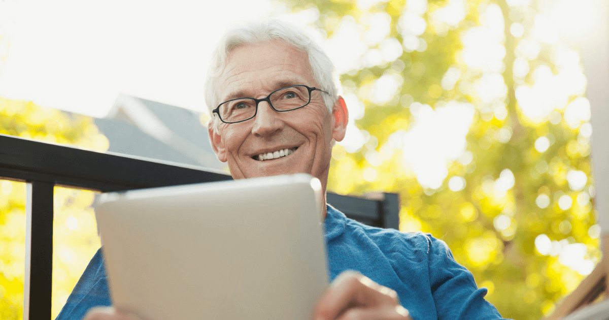 Senior man with laptop reviewing senior living